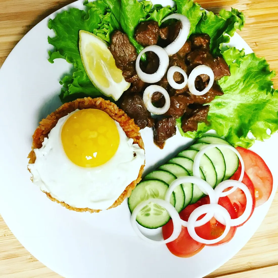 Filet de bœuf lôc lâc avec œuf au plat, riz sauté et crudités