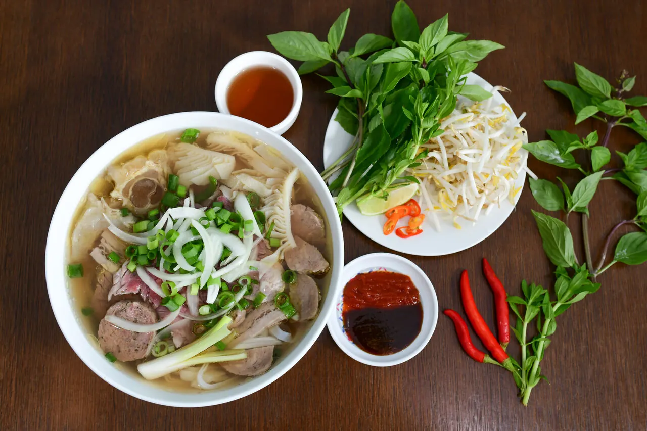 Bol de phô avec herbes fraîches et piments